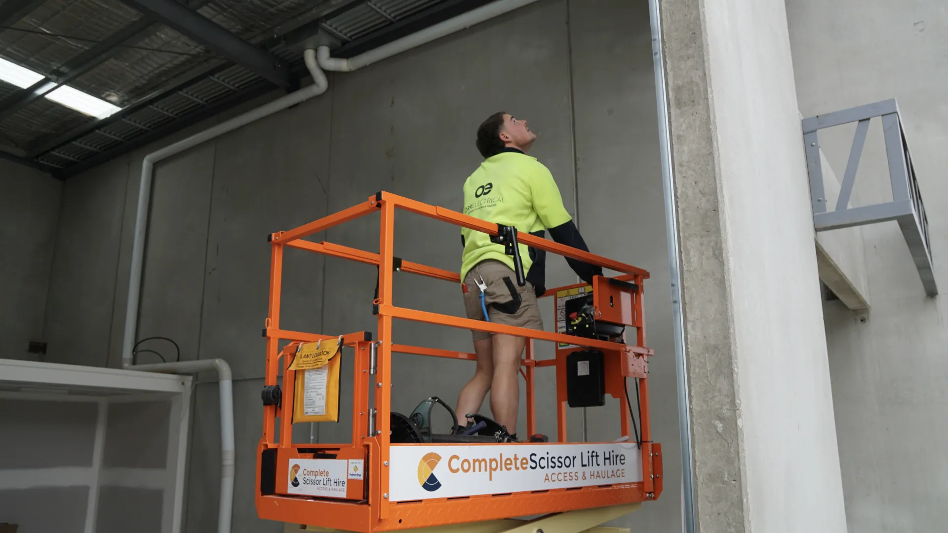 Orr Electrical electrician working from an elevated work platform in a commercial building